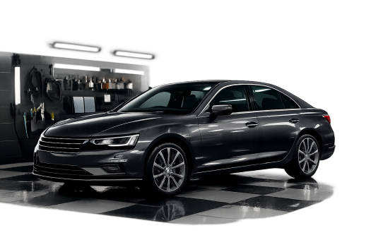 Freshly cleaned charcoal grey saloon car positioned in a clean, modern vehicle wash bay detailing garage